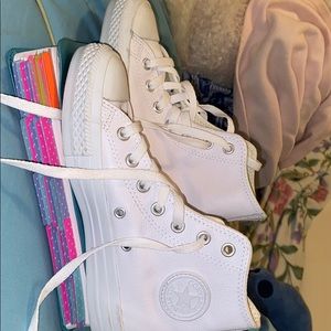 All white leather high-top converse.